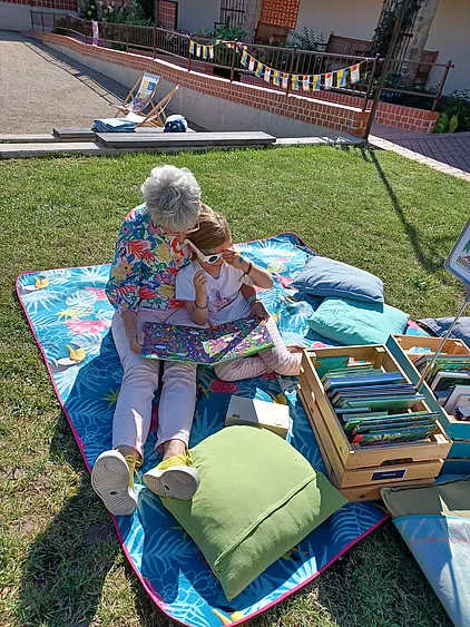 Ein Kind betrachtet ein Buch mit seiner Großmutter