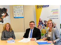 Projektleiterin Bildungsgemeinden Marlene Waxenegger, Landesrat Ludwig Schleritzko und BhW Geschäftsführerin Therese Reinel sitzen bei einem Tisch. Dahinter sieht man das Rollup des BhW Niederösterreich.