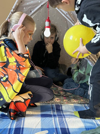 In Faschingskostümen verkleidete Kinder spielen in einem Forscher-Zelt. 