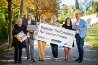Kursteilnehmerin Hermine Schlag, Trainer Hannes Giefing, Geschäftsführerin des Burgenländischen Volksbildungswerks Judith Tscheppe, BhW Geschäftsführerin Therese Reinel, Trainerin Julia Hentschel und kabelplus Geschäftsführer Wolfgang Schäffer stehen in einer Reihe und halten ein Schild „Digitale Treffpunkte für Senior/innen“ in die Kamera. 