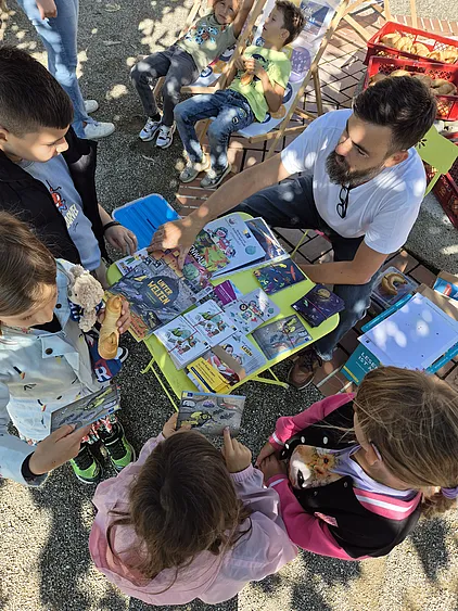 Kinder holen Gewinne beim Stand von Zeit Punkt Lesen ab
