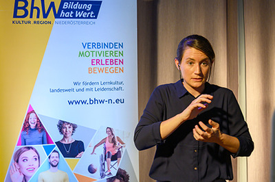 Gebärdensprachdolmetscherin beim gebärden bei einer Veranstaltung.