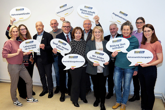 Gruppenbild mit BHW Vorstand und Support Ehrenamt Team. Die Personen halten große Sprechblasen in die Höhe mit einigen Schlagworten zum Tag des Ehrenamtes.