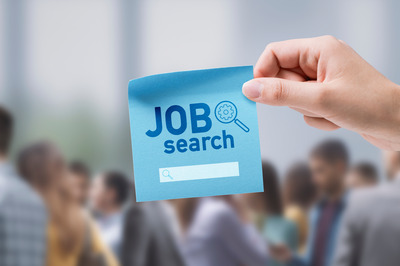 Eine Hand hält einen Klebezettel mit der Aufschrift "Job Search" in den Bildschirm. 