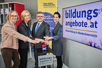 Das Team der Steuerungsgruppe und LR Schleritzko halten die Hände symbolisch über einem Buzzer, der die neue Bildungsdatenbank einläutet.