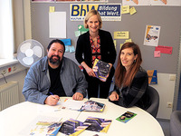 Gruppenbild mit Jakob Sint, Therese Reinel und Birgit Schierhuber. Sie sitzen an einem Tisch auf dem einige Exemplare der Barrierefrei-Broschüren liegen.