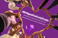 Teammitglieder des BhW formen mit ihren Händen ein großes Herz. In der Mitte steht: „#BhWgoesPositivelyPurple. Gemeinsam barrierefrei: Für ein Niederösterreich ohne Hindernisse“