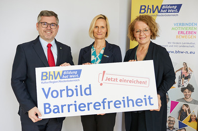 Gruppenbild, Landesrat Ludwig Schleritzko, BhW Geschäftsführerin Therese Reinel und Landesrätin Christiane Teschl-Hofmeister stehen vor einem BhW_Rollup und halten ein Schild hoch, auf dem steht: Vorbild Barrierefreiheit - Jetzt einreichen!