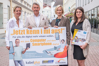 Auf dem Foto sind zu sehen: Geschäftsführerin des Burgenländischen Bildungswerks Judith Tscheppe,  kabelplus-Geschäftsführer Wolfgang Schäffer, Geschäftsführerin des BhW Niederösterreich Therese Reinel und Smartphone-Trainerin Julia Hentschel. Sie alle halten eine Tafel mit der Aufschrift „Jetzt kenn i mi aus! – Für alle, die digital mehr wissen wollen“ zur Bewerbung von gemeinsam durchgeführten Online-Workshops zu Computer- und Smartphone-Themen. 