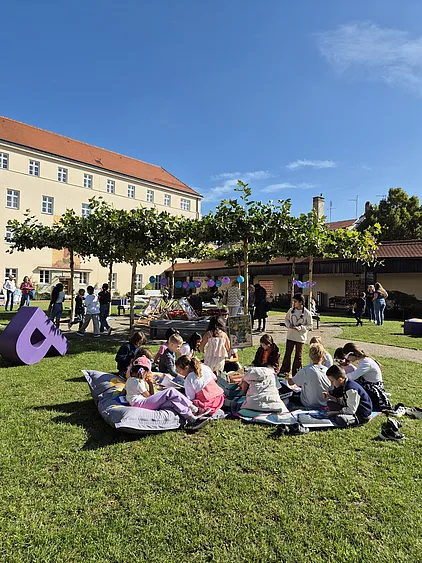 Kinder lesen gemeinsam im Alumnatsgarten