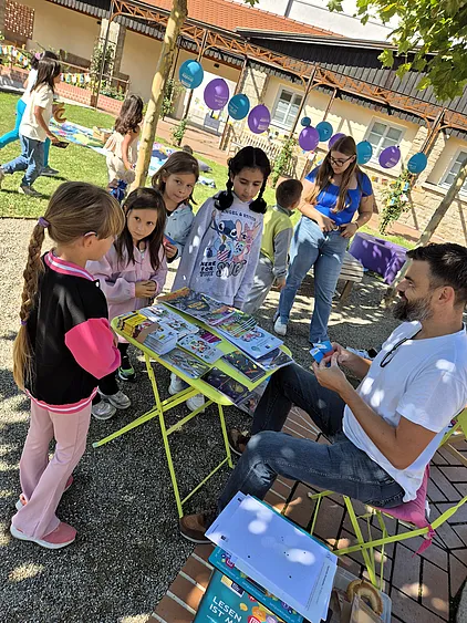 Kinder holen ihre Gewinne beim Stand von Zeit Punkt Lesen ab