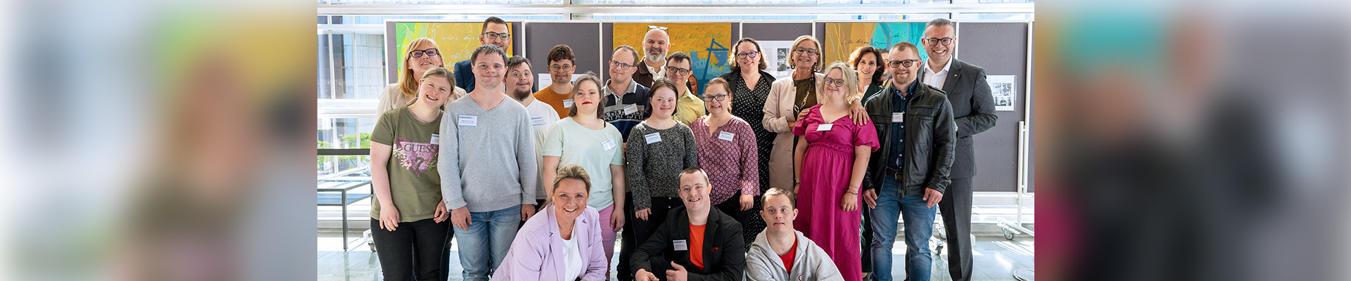 Nicole Steinacher, Krassimir Kolev, Landeshauptfrau Johanna Mikl-Leitner und Landesrätin Susanne Rosenkranz stehen mit den Models vor bunten Gemälden.
