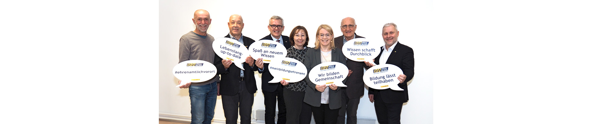 Gruppenbild mit BHW Vorstand und Support Ehrenamt Team. Die Personen halten große Sprechblasen in die Höhe mit einigen Schlagworten zum Tag des Ehrenamtes.
